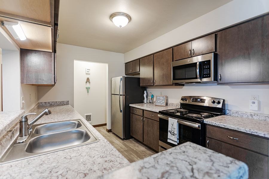 A kitchen with a sink, stove, and refrigerator.