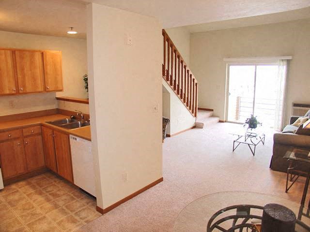 a kitchen and a living room with a staircase