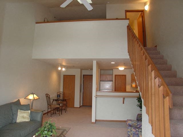 a living room with a staircase  and a kitchen