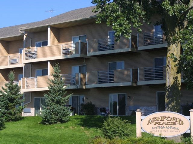 an apartment building with a sign in front of it