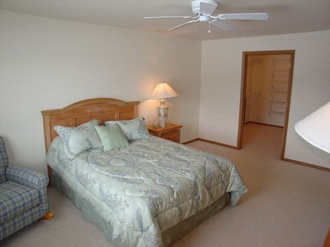 a bedroom with a bed and a ceiling fan