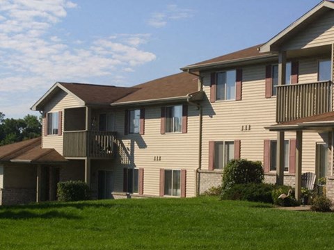 a large apartment building with a green lawn