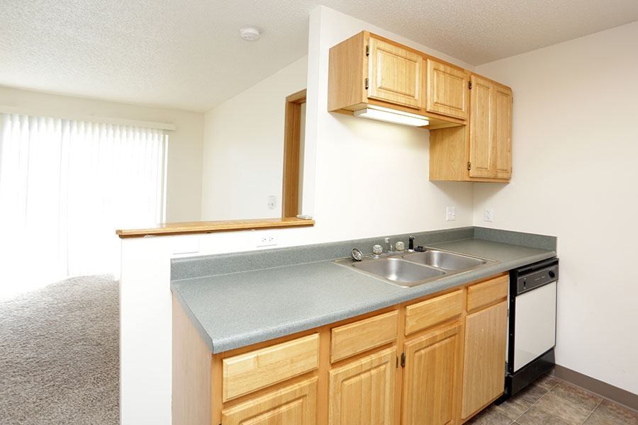 A kitchen with wooden cabinets and a grey countertop.