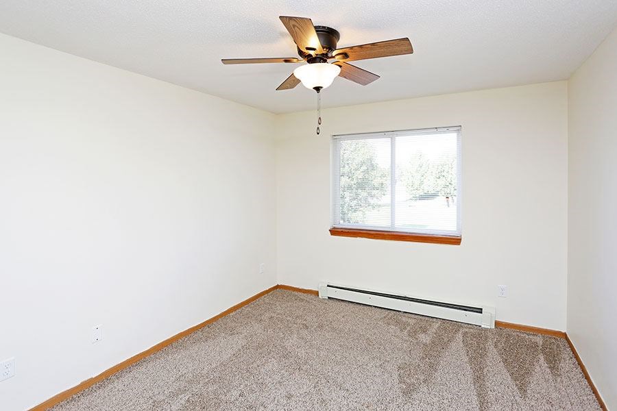 A room with a ceiling fan and a window.