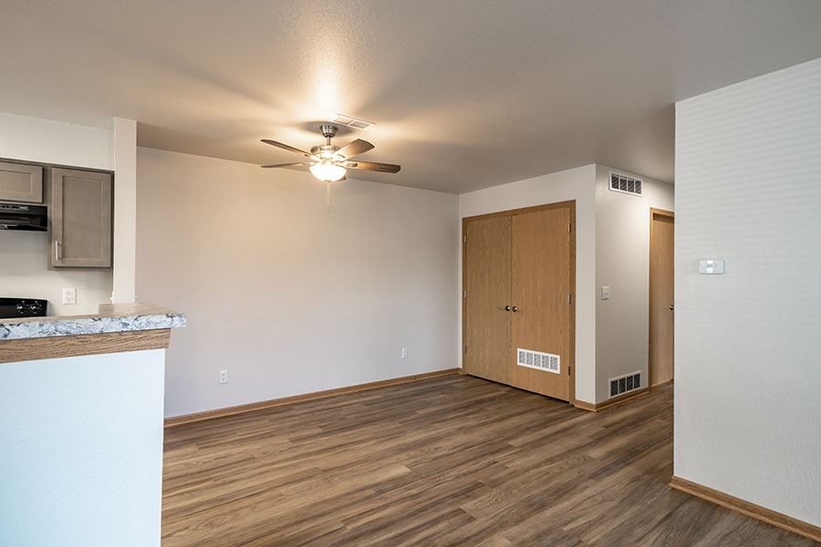 A room with a ceiling fan and a wooden floor.