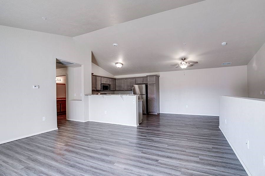 A spacious room with a kitchen area in the background.