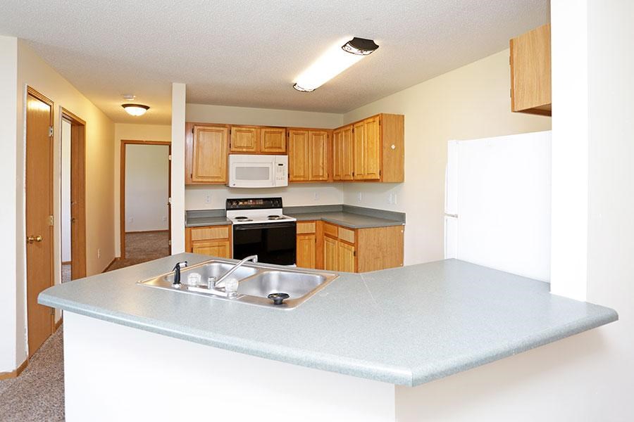 A kitchen with a sink and a refrigerator.