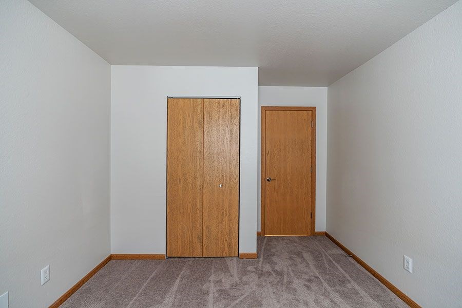 Two brown doors in a white room.