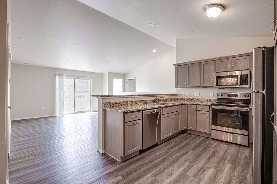 A kitchen with a refrigerator on the right side.