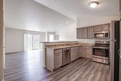 A kitchen with a refrigerator on the right side.
