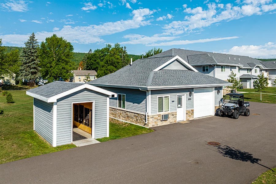 A house with a garage and a car parked in front.