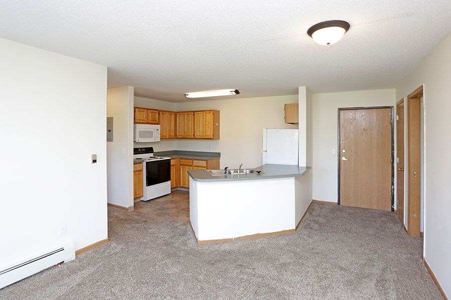 A kitchen with white appliances and wooden cabinets.
