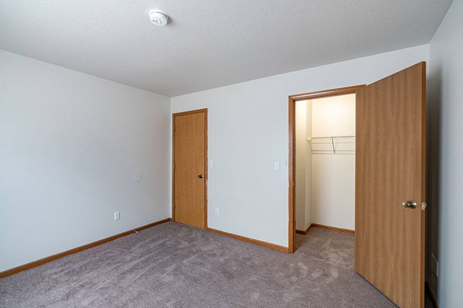 A room with two doors and a carpeted floor.