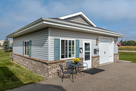 A house with a grey siding and a white door is shown.