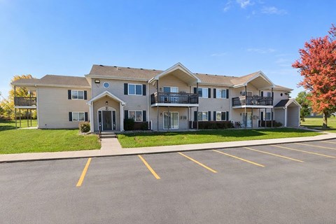 A large apartment complex with a parking lot in front.