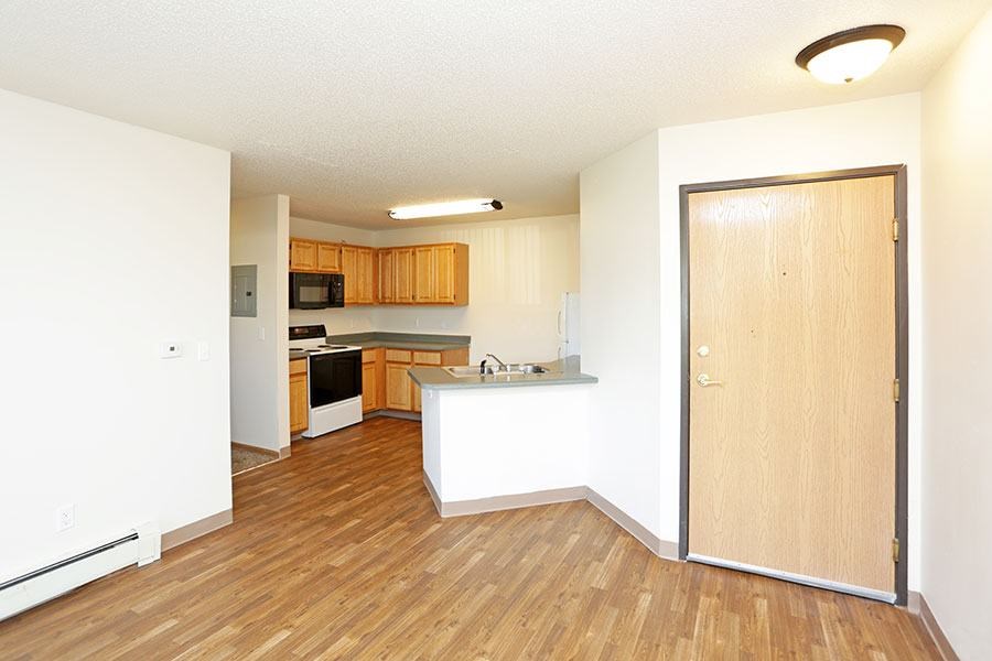 A kitchen with wooden floors and white walls.