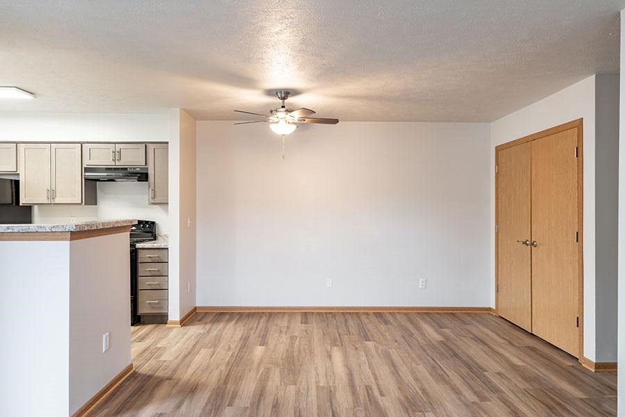 A kitchen with white cabinets and a wooden floor.