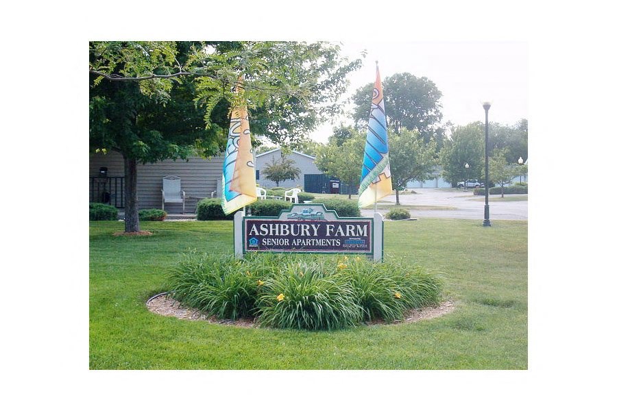 a sign farm sign with flags in the grass