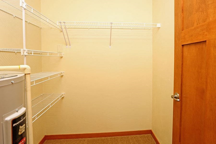 a walk in closet with a white wall and a door