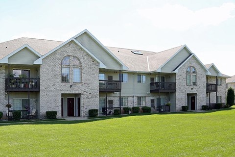 a large house with a green lawn in front of it