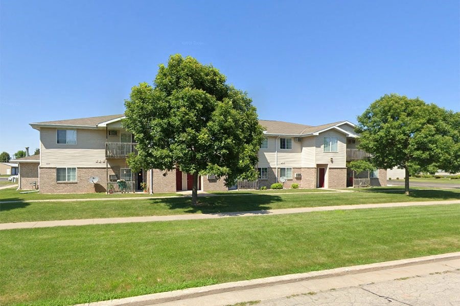 an apartment building with green grass and trees