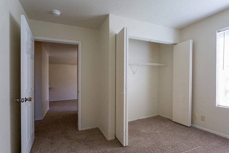 an empty room with a closet and an open door