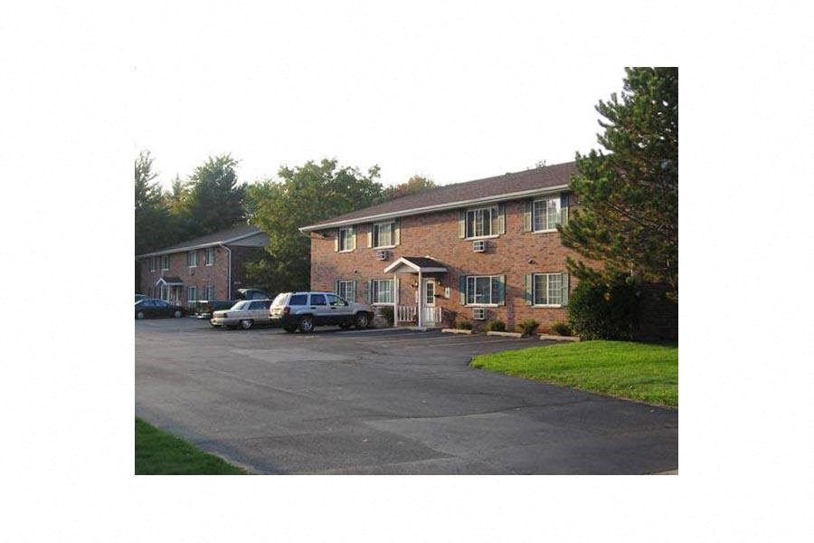 a brick house with cars parked in the driveway
