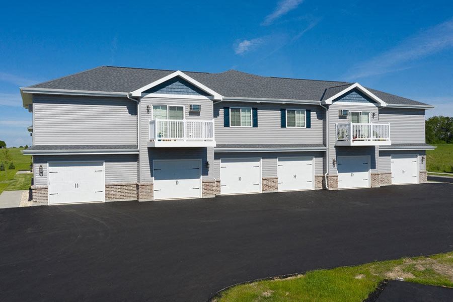 a white house with white doors and a black road