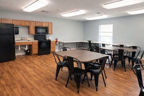 A kitchen area with a dining table and chairs.
