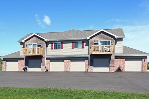 a house with two balconies and a parking lot