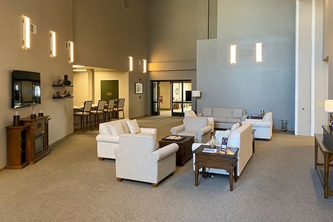 A living room with white furniture and a flat screen TV.
