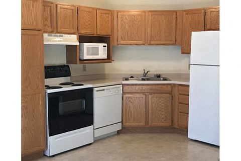 a kitchen with white appliances and wooden cabinets