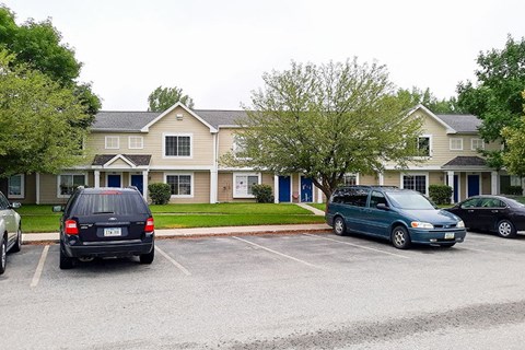 two cars parked in a parking lot in front of a house