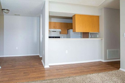 A kitchen area with wooden cabinets and a white countertop.