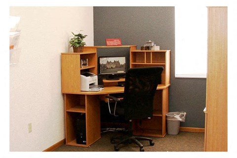 a desk with a computer and a chair
