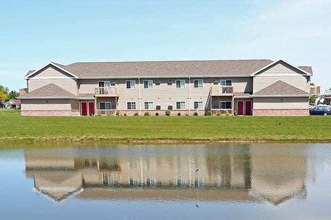 a large building with a pond in front of it