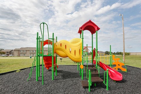 a playground with a yellow and red swing set