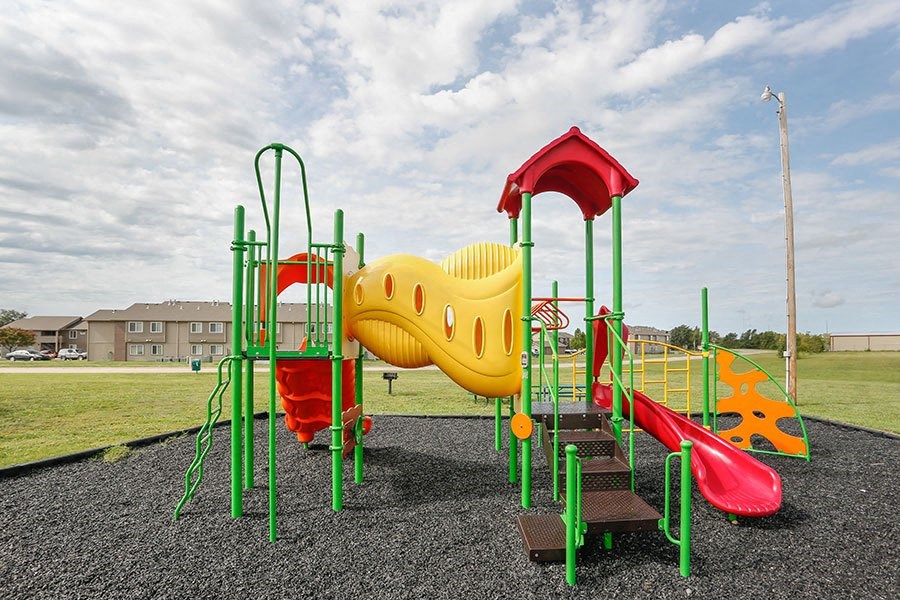 a playground with a yellow and red swing set