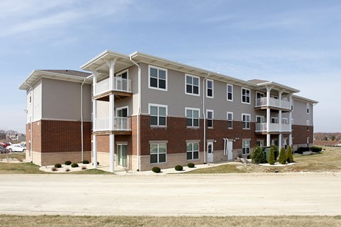 A large apartment building with multiple balconies and doors.