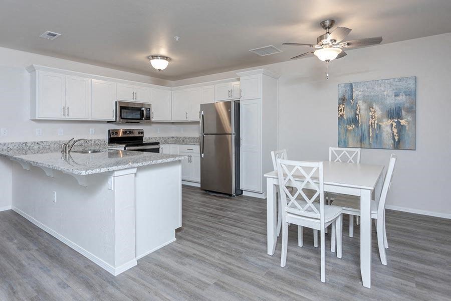 A kitchen with a marble countertop and a refrigerator.