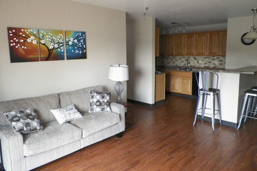A living room with a couch and a painting on the wall.