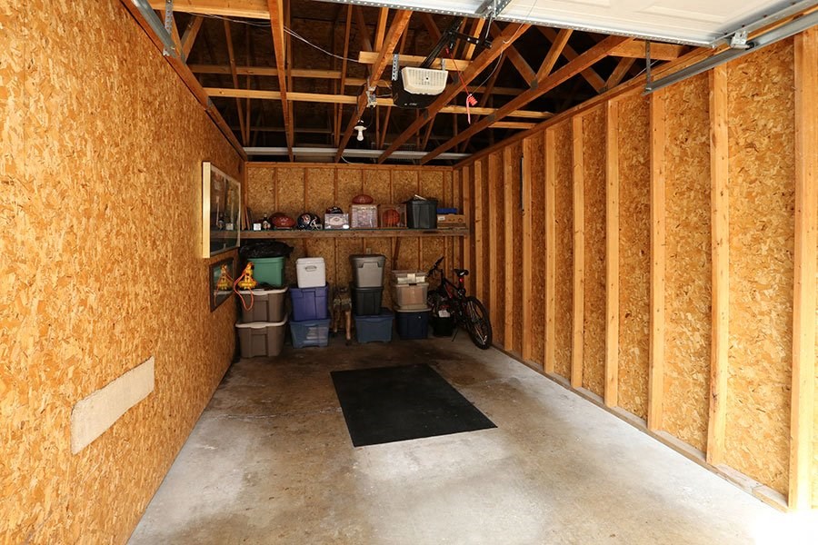 A room under construction with a lot of wood paneling and a black mat on the floor.