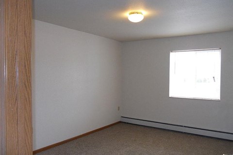 A room with a window and a light on the ceiling.