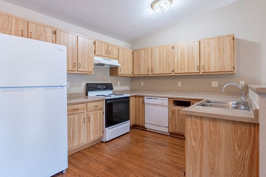 A kitchen with wooden cabinets and a white refrigerator.
