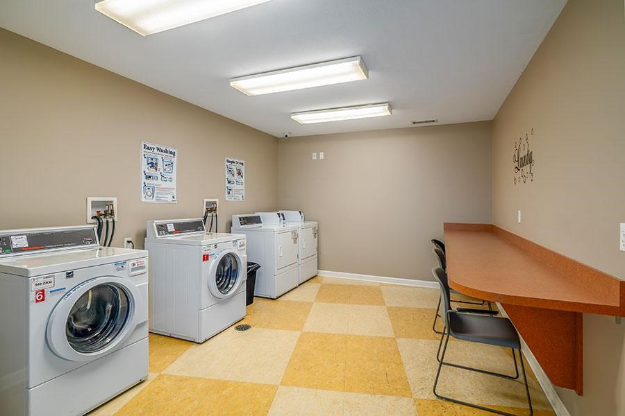 A laundry room with washers and dryers and a checkered floor.