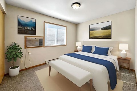 A bedroom with a large bed and a potted plant.