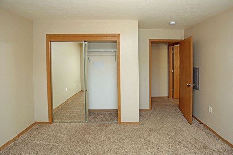 a empty room with a closet and a mirrored door