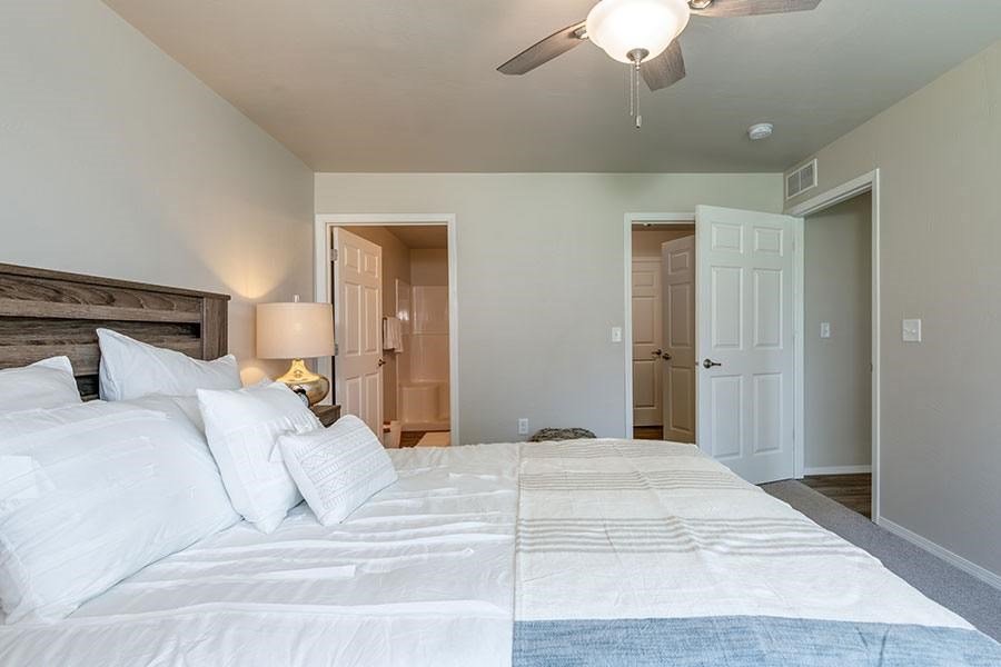A bedroom with a large bed and a ceiling fan.