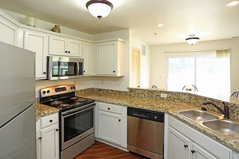 a kitchen with stainless steel appliances and white cabinets