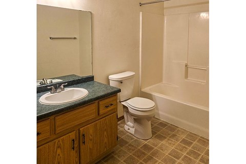 A bathroom with a toilet, sink, and bathtub.